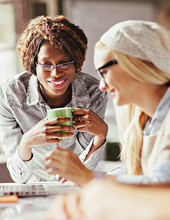 collega's die kopjes koffie houden en glimlachen terwijl ze werken